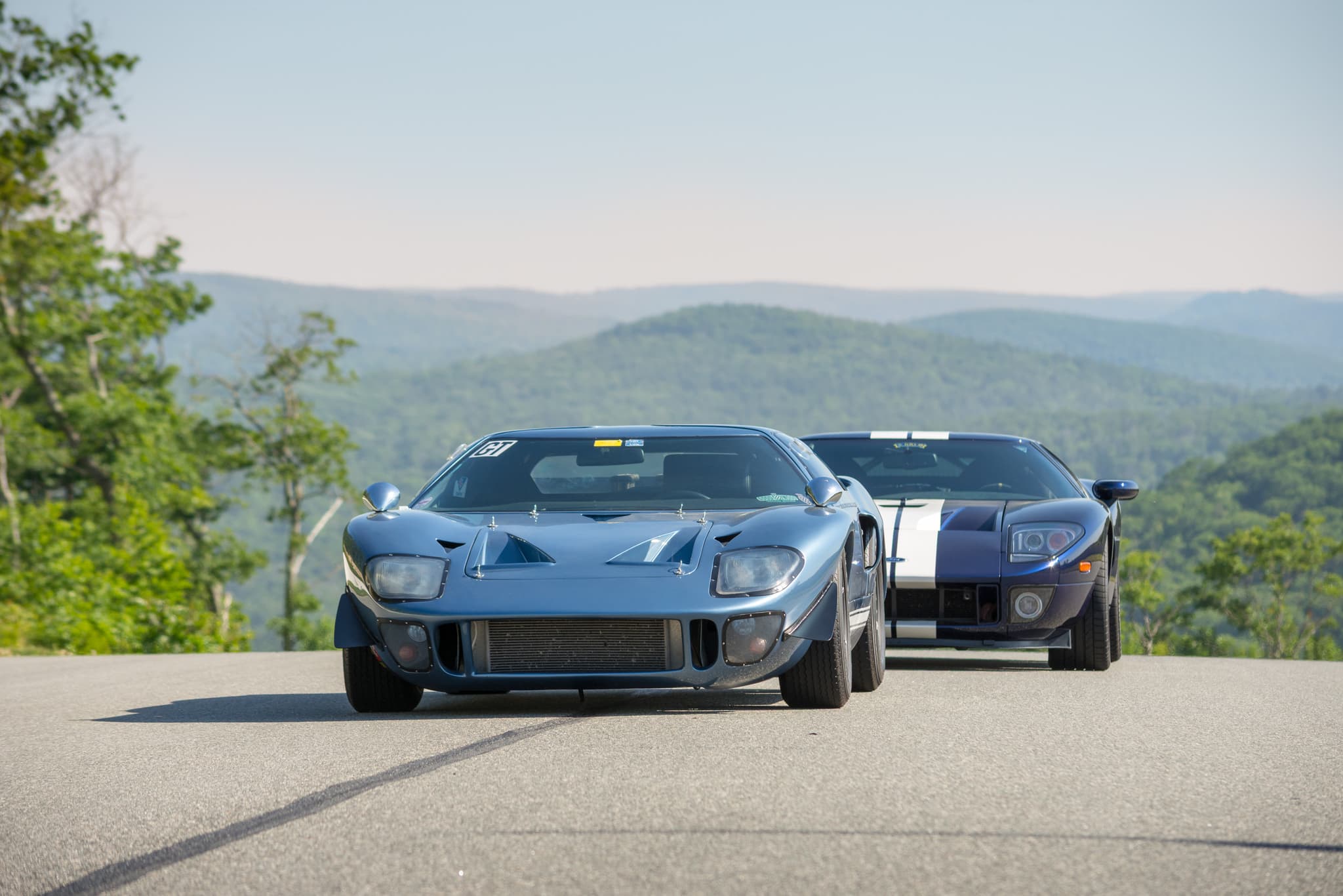 Ford GT40 and modern Ford GT on rolling New England hills — automotive photography